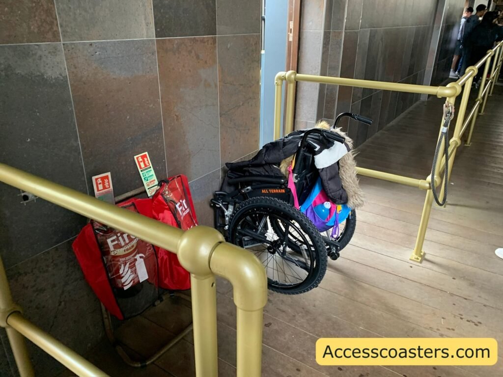 image of ride station area with opening next to wall between barriers with wheelchair parked 