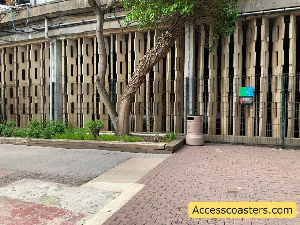 A view of an exterior wall next to a wide a paved walkway with easy access and speedy access entrance sign on the wall 