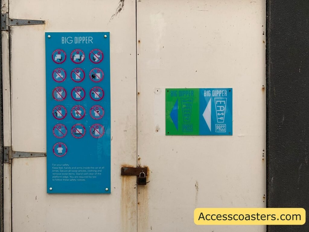 image shows wall with ride restriction board for big dipper, speed pass and easy pass entrance signs with arrows pointing left. 