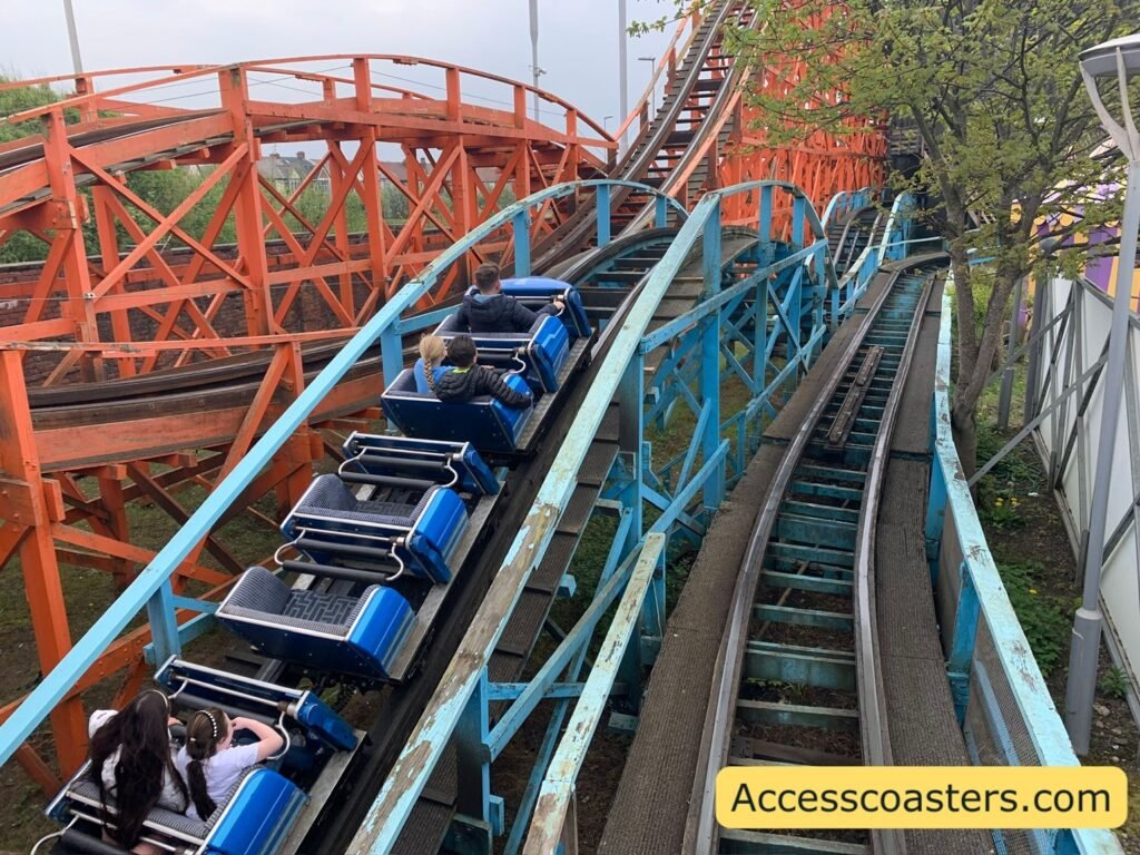 image of train going up the lift hill of blue flyer wooden track to the right you can see an orange track for the Nickelodeon streak rollercoaster. 