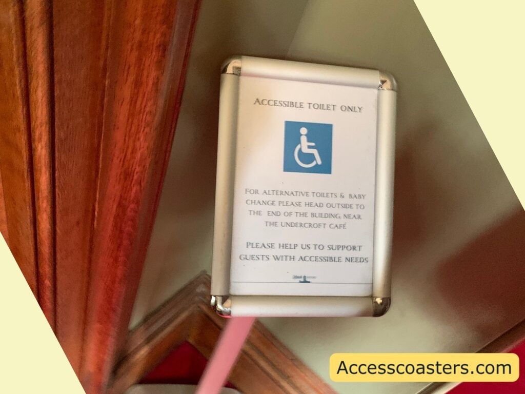 a framed sign on a wooden wall at Warwick Castle reading “Accessible Toilet Only” with the wheelchair symbol and smaller text beneath, indicating that an accessible toilet is available for disabled guests