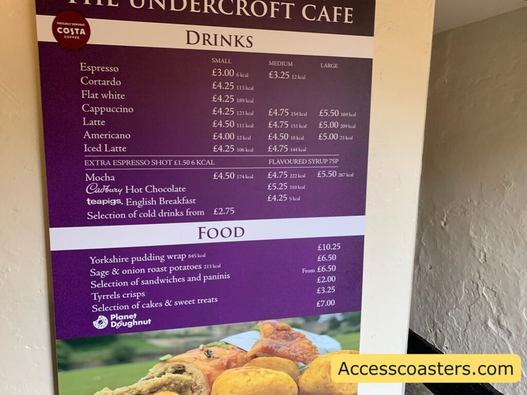 Undercroft Café menu board at Warwick Castle showing Costa-branded hot drinks and a list of hot food options with prices.
