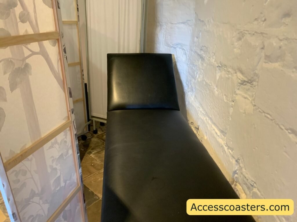 Black padded changing or therapy bench against the stone wall inside the Welfare and Sensory Room