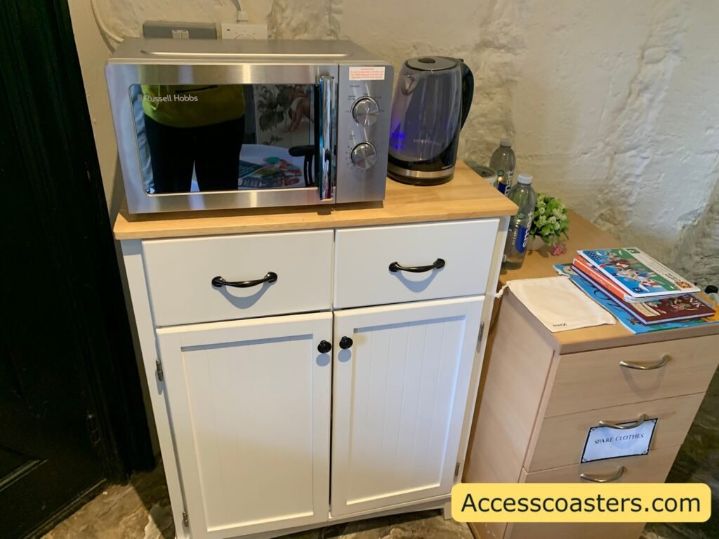 Small kitchenette area in the Welfare and Sensory Room with a microwave, electric kettle, and storage cupboards