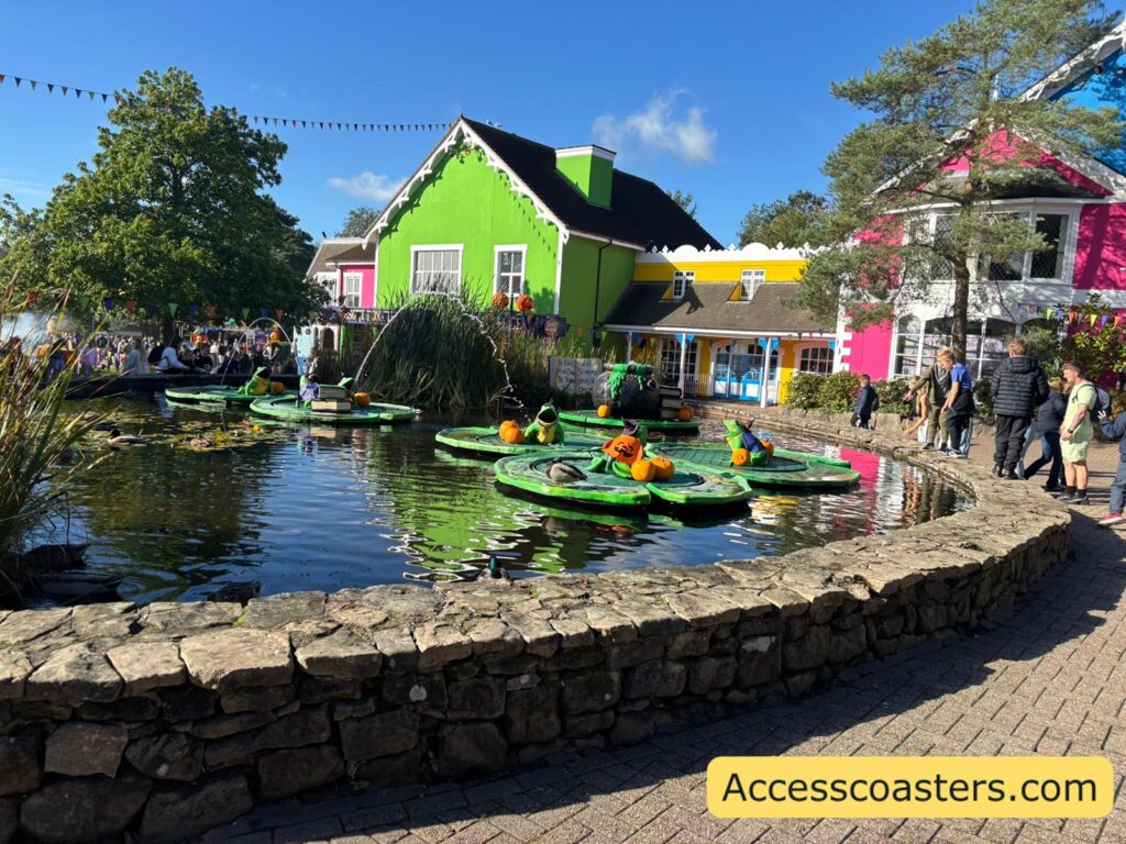 image of a lake of water with modal frogs on lilly pads dressed in Halloween costumes. 